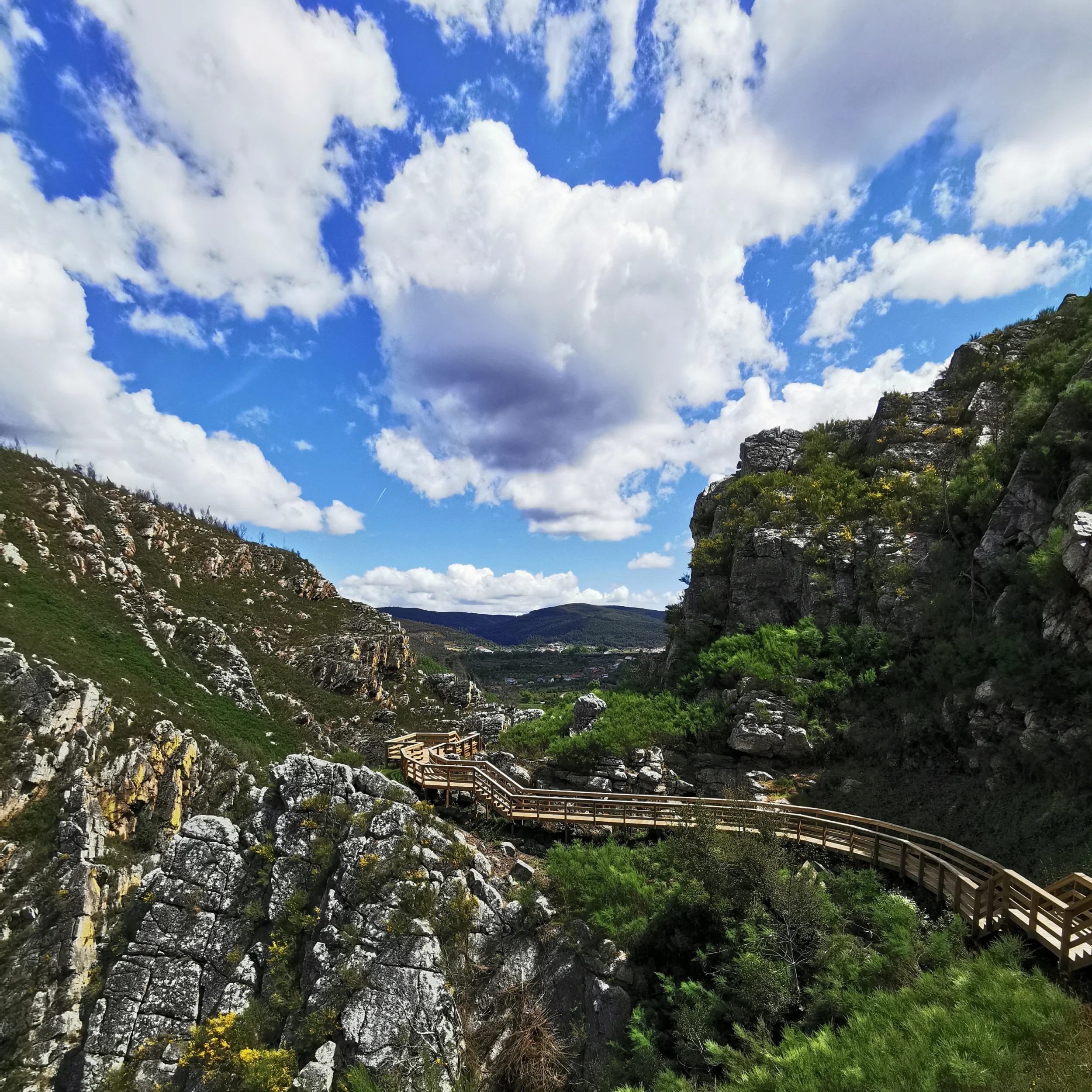 Mountain views and walkways with many rock formations and green bushes.