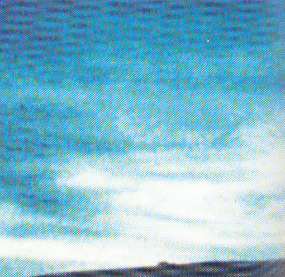 Extremely blurry photo of a clear sky, probably provoked by the enlargement beyond its resolution until you can actually see the printing, dotted pattern